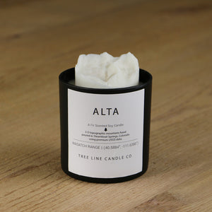  A white soy wax replica candle of Alta summit in a round, black glass.