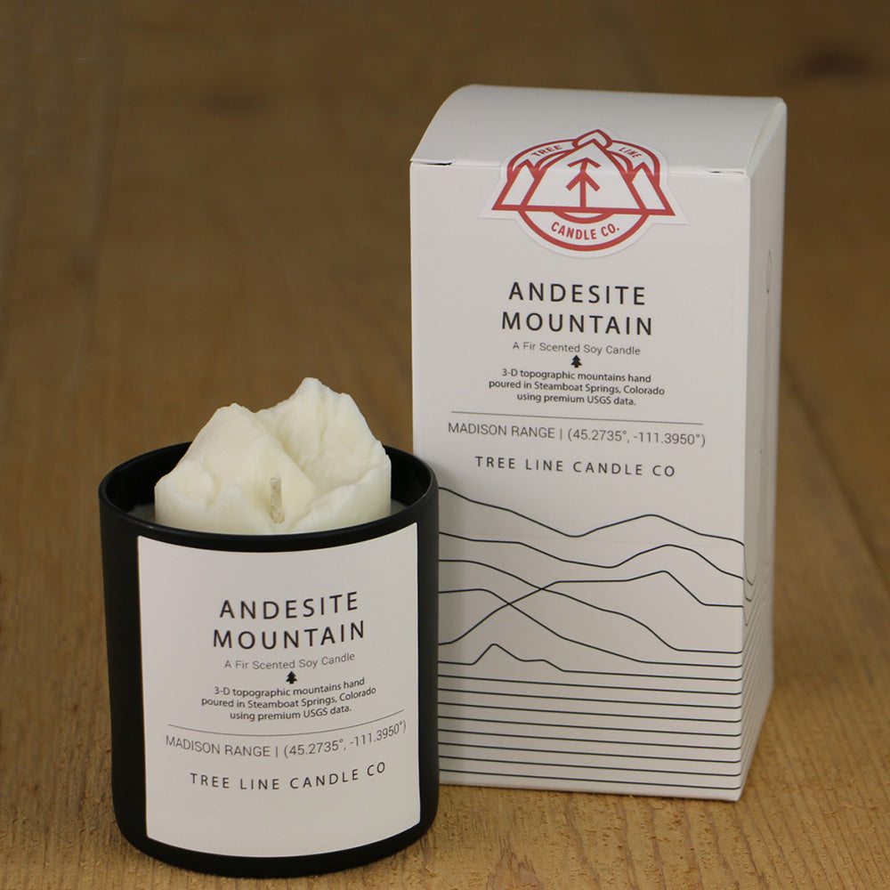 A white wax candle named Andesite Mountain is next to a white box with red and black lettering.