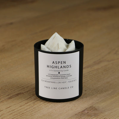  A white soy wax replica candle of Aspen Highlands in a round, black glass.