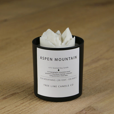  A white soy wax replica candle of Aspen Mountain in a round, black glass.