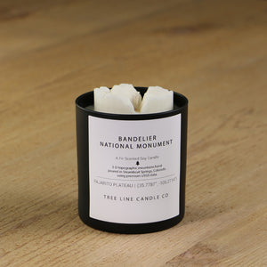  A white soy wax replica candle of Bandelier National Monument in a round, black glass.
