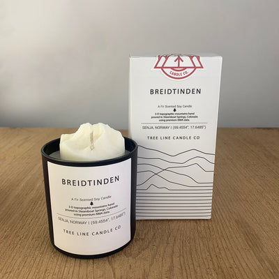 A white wax candle named Breidtinden is next to a white box with red and black lettering.