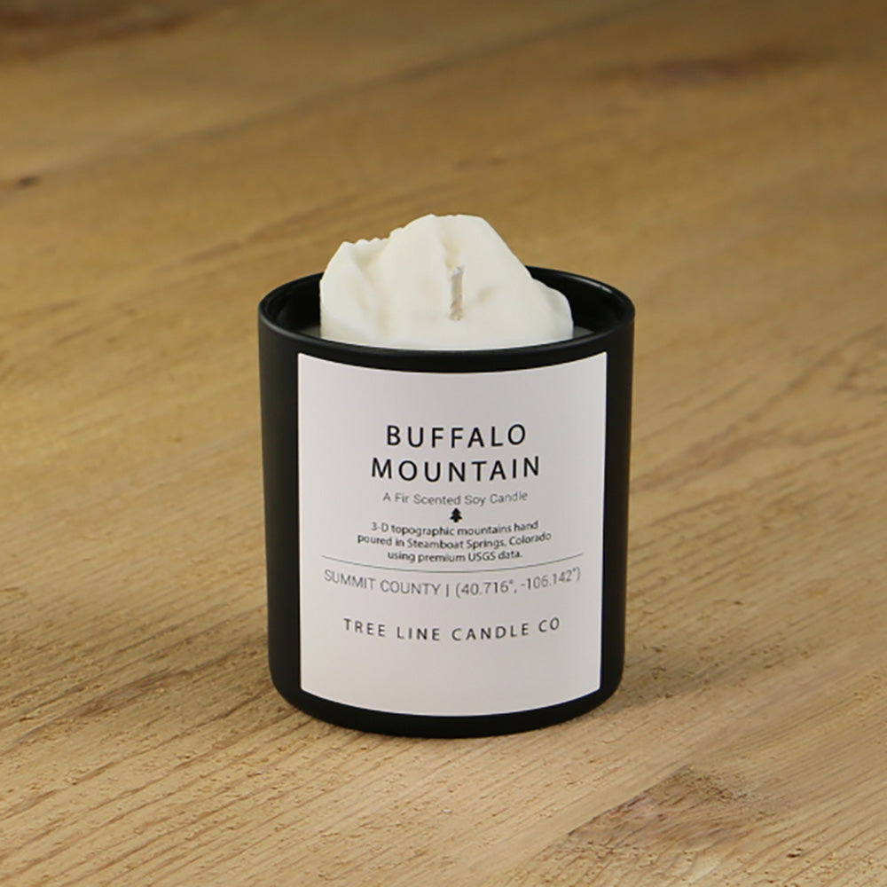 A white soy wax replica candle of Buffalo Mountain in a round, black glass.