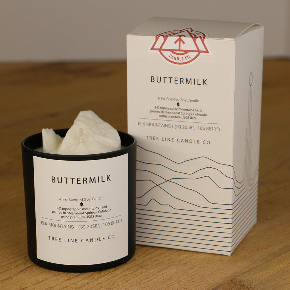 A white wax candle named Buffalo summit is next to a white box with red and black lettering.