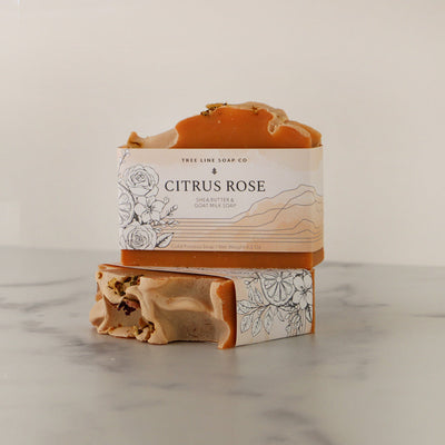 A bar of oangey pink soap, Citurs Rose sits atop another bar of soap.