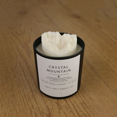  A white soy wax replica candle of Crystal Mountain in a round, black glass.