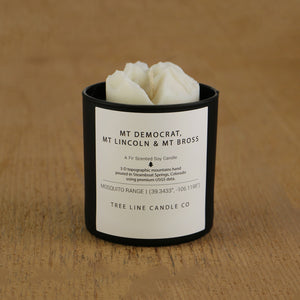 A white soy wax replica candle Mt. Democrat, Mt. Lincoln & Mt. Bross in a round, black glass.