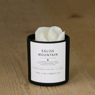  A white soy wax replica candle of Eglise Mountain in a round, black glass.