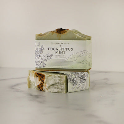 A bar of Eucalyptus Mint soap sits atop another bar of soap with the same fragrance.