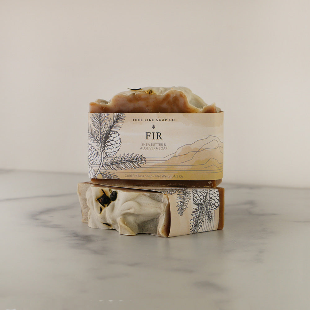 A single bar of Fir soap sits atop another bar of the same fragrance.
