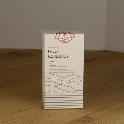A white box with black lettering and a red and white Tree Line Candle Co.  logo.