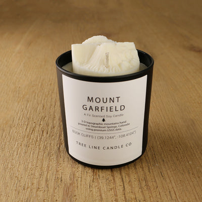  A white soy wax replica candle of Mount Garfield in a round, black glass.