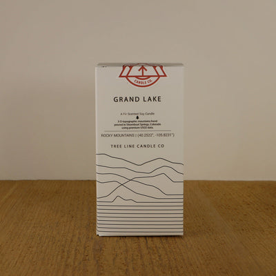 A white box with black lettering and a red and white Tree Line Candle Co.  logo.