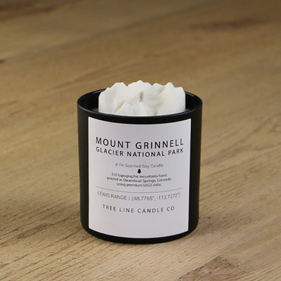  A white soy wax replica candle of Mount Grinnell Glacier in a round, black glass.