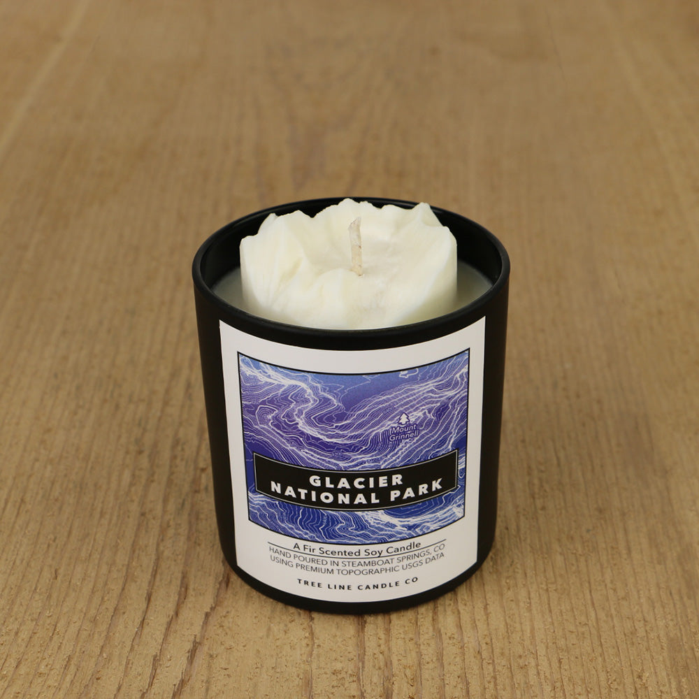  A white soy wax replica candle of Mount Grinnell in a round, black glass.