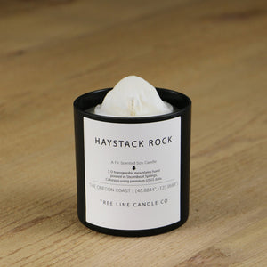  A white soy wax replica candle of  Haystack Rock in a round, black glass.