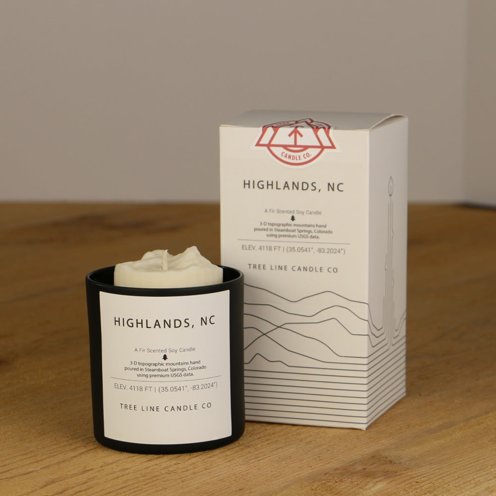 A white wax candle named Highlands is next to a white box with red and black lettering.