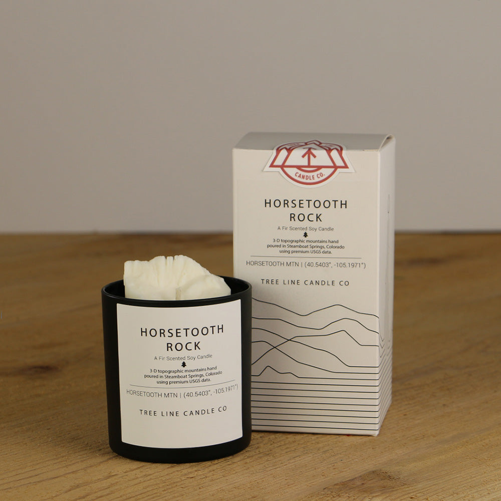 A white wax candle named Horsetooth is next to a white box with red and black lettering.