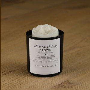  A white soy wax replica candle of Mt. Mansfield Stowe in a round, black glass.