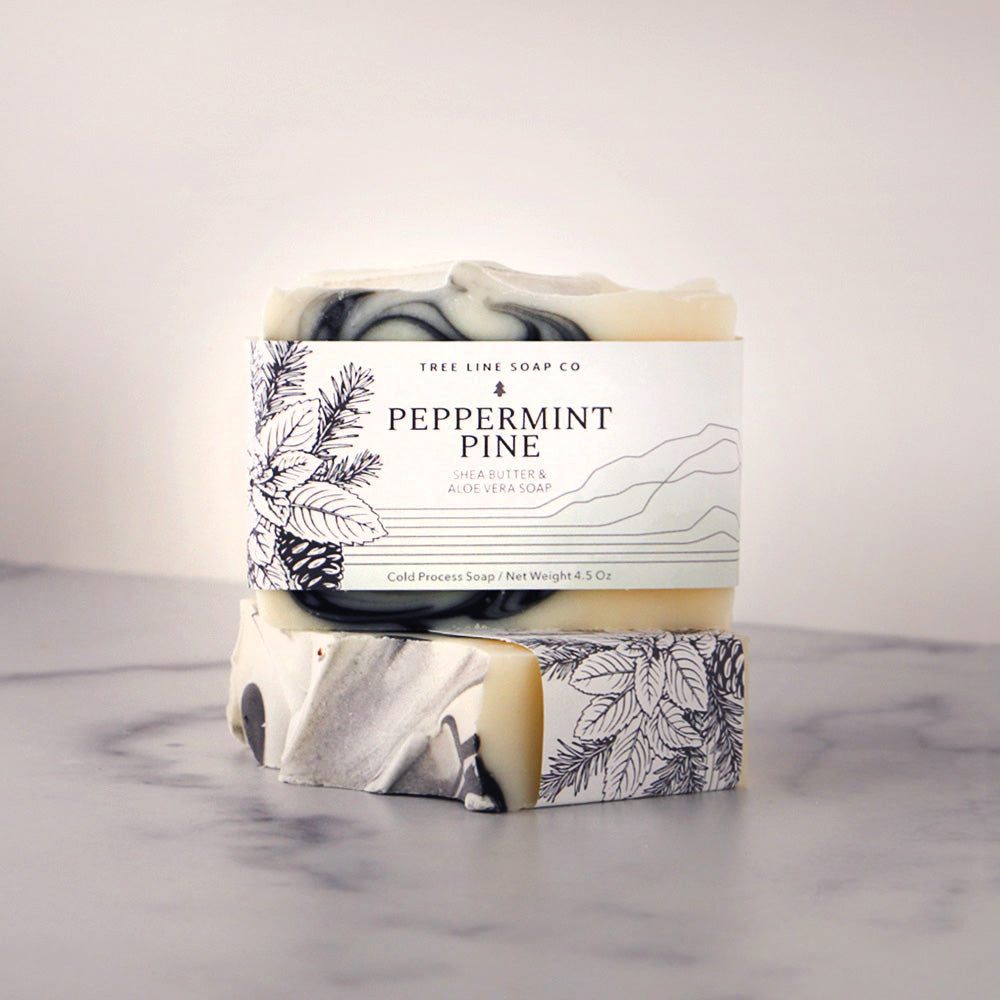 A bar of Peppermint Pine soap sits atop another bar of the same fragrance.