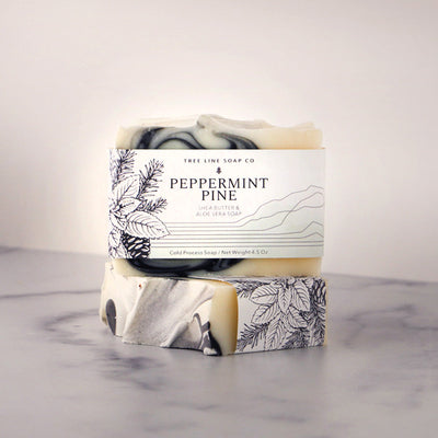 A bar of Peppermint Pine soap sits atop another bar of the same fragrance.