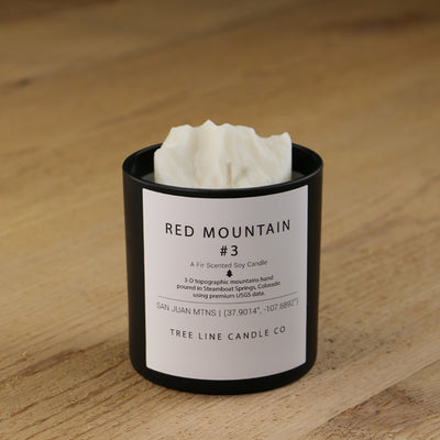  A white soy wax replica candle of Red Mountain #3 in a round, black glass.