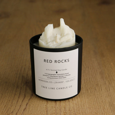 A white soy wax replica candle of Red Rocks in a round, black glass.
