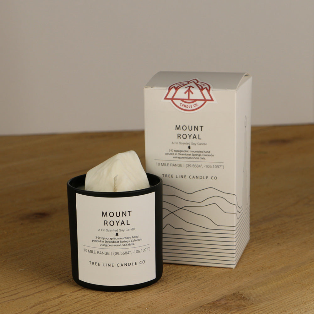 A white wax candle named Mount Royal is next to a white box with red and black lettering.