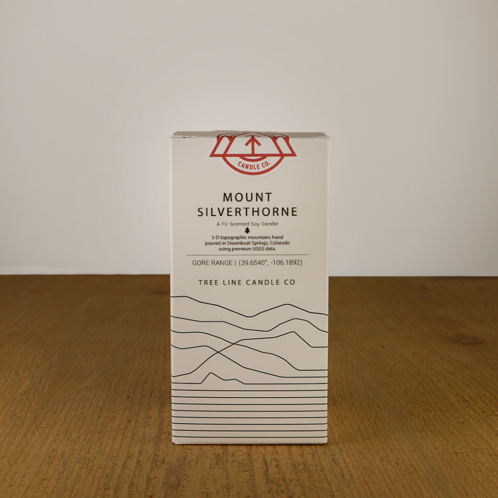 A white box with black lettering and a red and white Tree Line Candle Co.  logo.