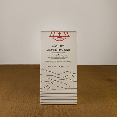 A white box with black lettering and a red and white Tree Line Candle Co.  logo.