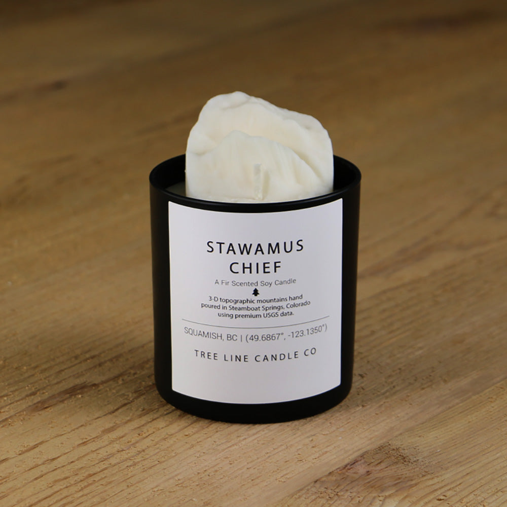A white soy wax replica candle of Stawamus Chief summit  in a round, black glass.
