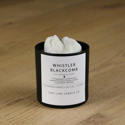  A white soy wax replica candle of Whistler Blackcomb summit in a round, black glass.
