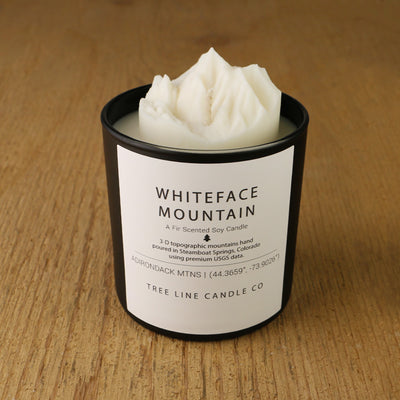  A white soy wax replica candle of Whiteface Mountain in a round, black glass.